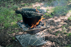 焚き火台におき 火を作り、鍋をの せ、蓋の上にもお き火をのせてオー ブン状態にし、焼 き上げる。