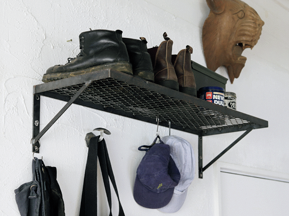 壁に取り付けた黒い金属製の棚。上にブーツが数足