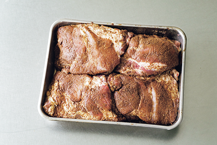 バットの中の肉。スペアリブの塊肉に下味をつける。