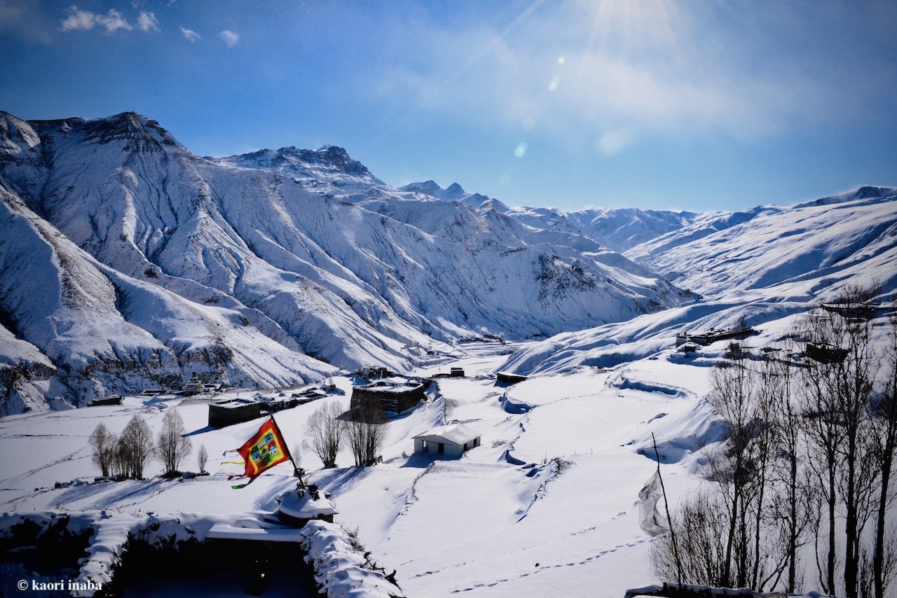 ドルポのサルダン村。雪に覆われた山々と家、赤い旗