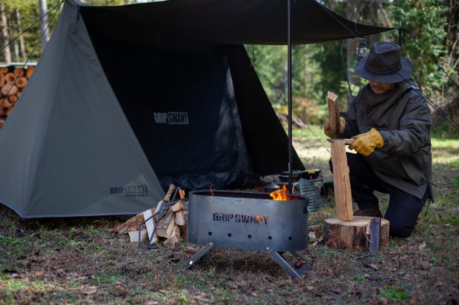 テントの前焚き火台で火おこしをする。