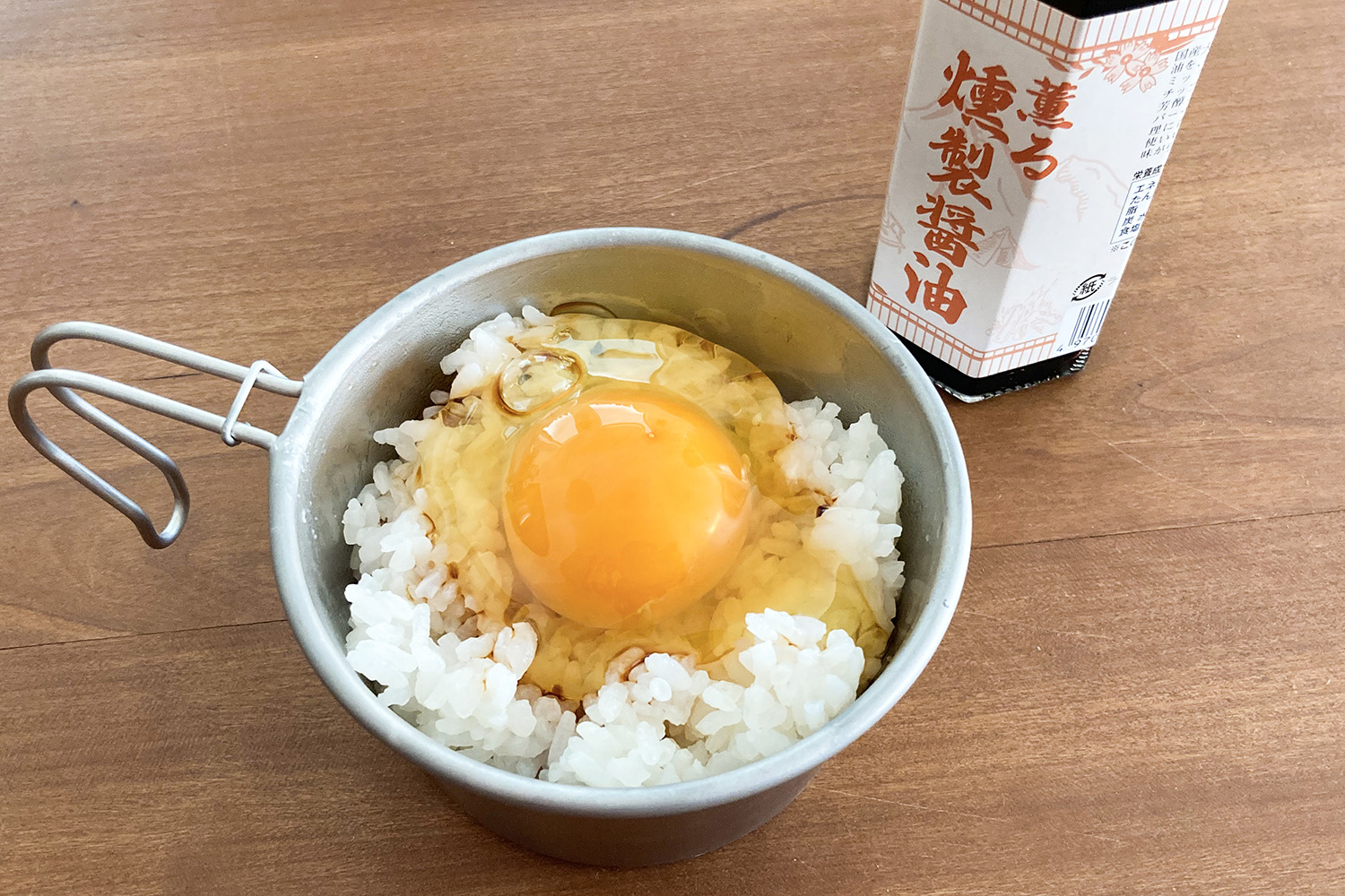 シェラカップに盛った卵掛けご飯と燻製醤油