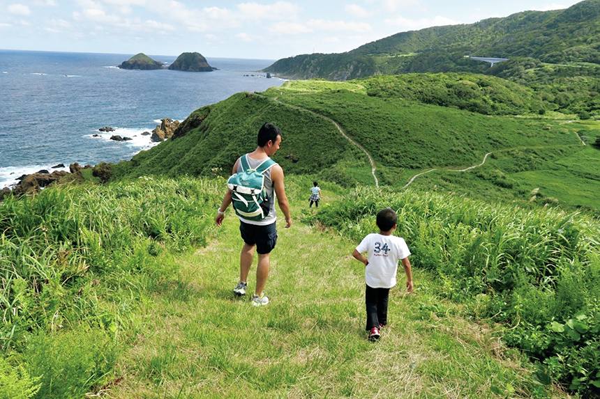 緑にあふれた島をハイキングする親子