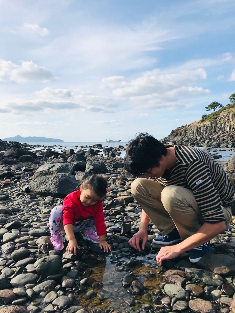 海岸で生き物観察をする親子