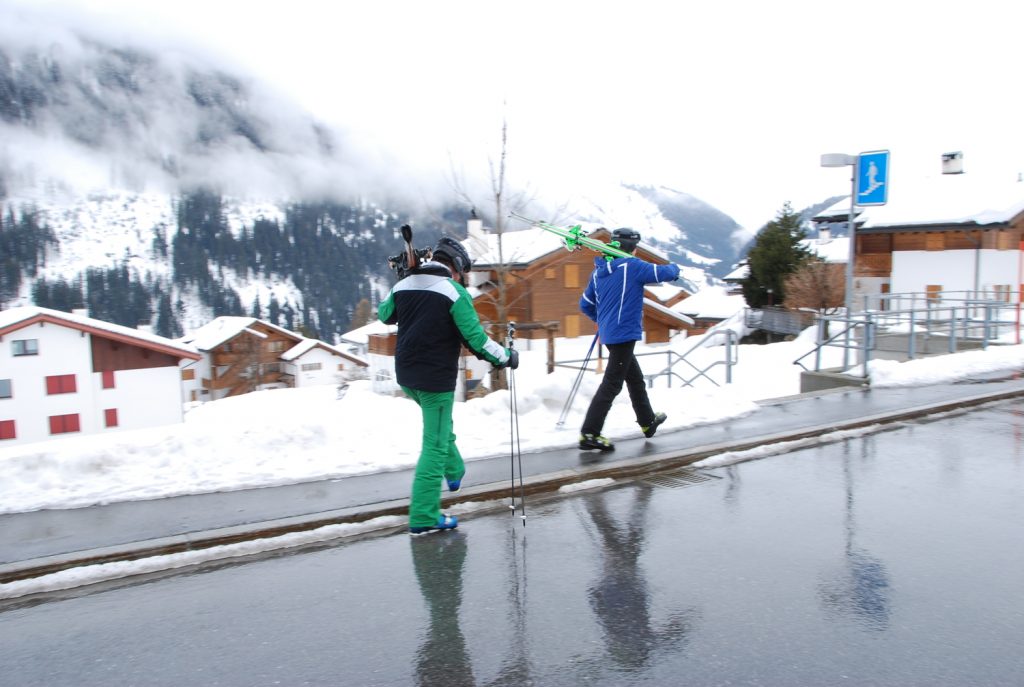 スイスの道路を歩くスキーヤー