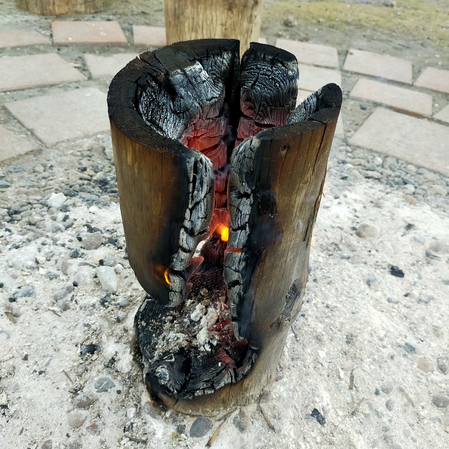 火が燃え広がり、丸太ストーブの上部の穴と側面の穴が繫がっている。