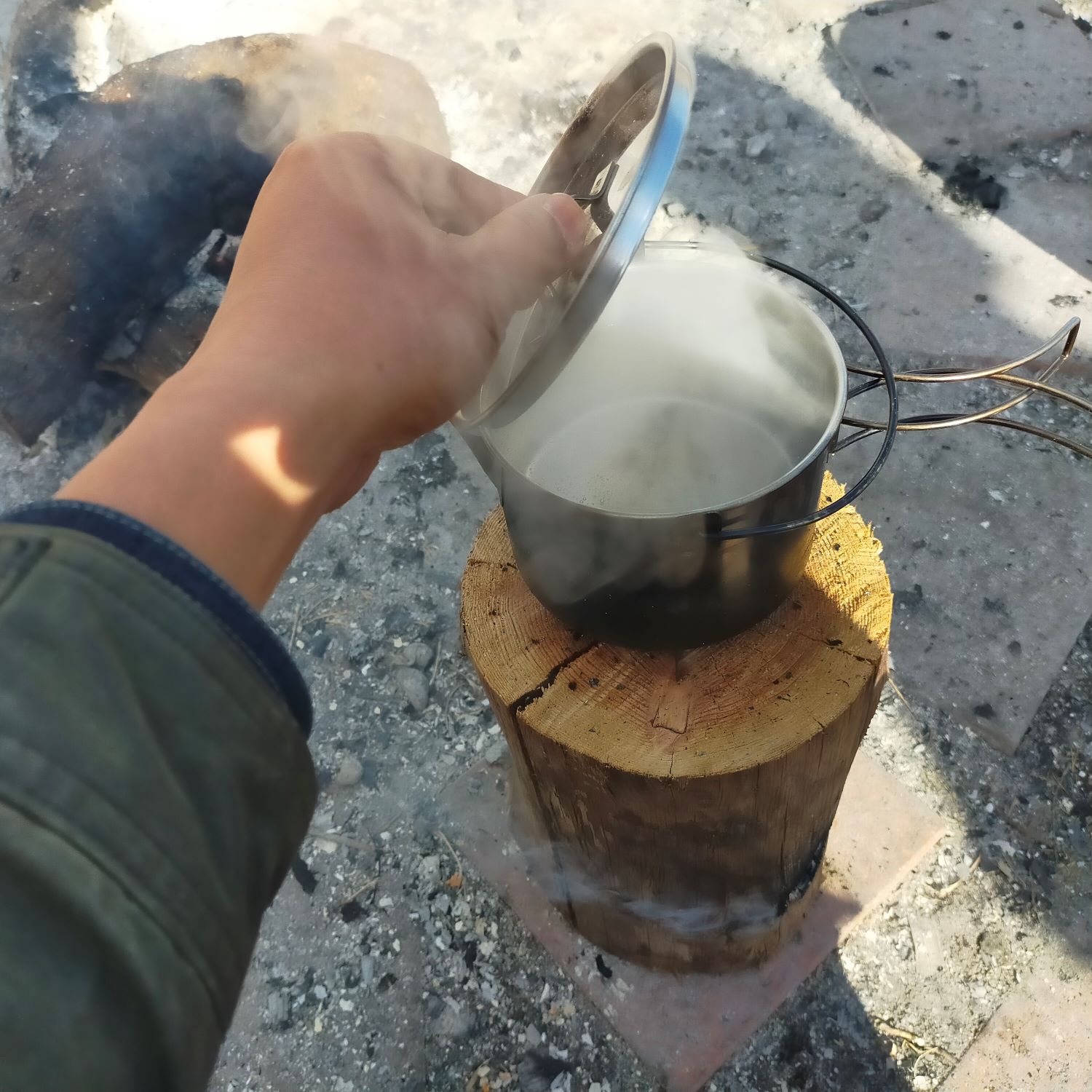 丸太ストーブの上に置いたケトルの中から湯気が上っている。