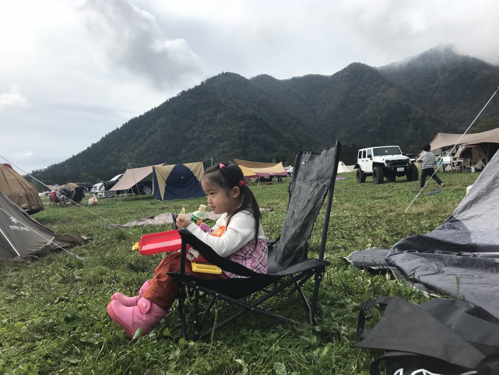 キャンプで椅子に座った少女