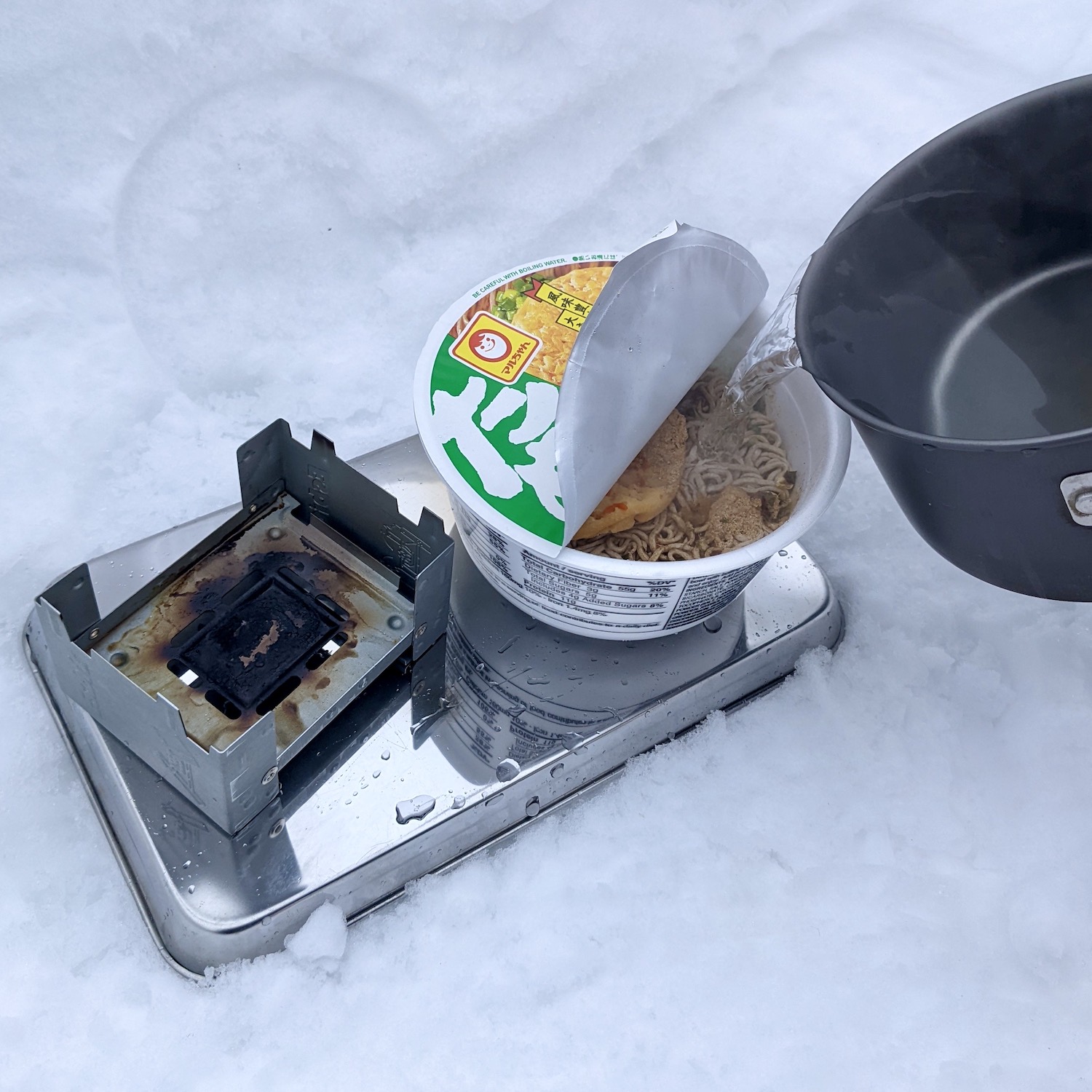 カップ麺にお湯を注いでいる