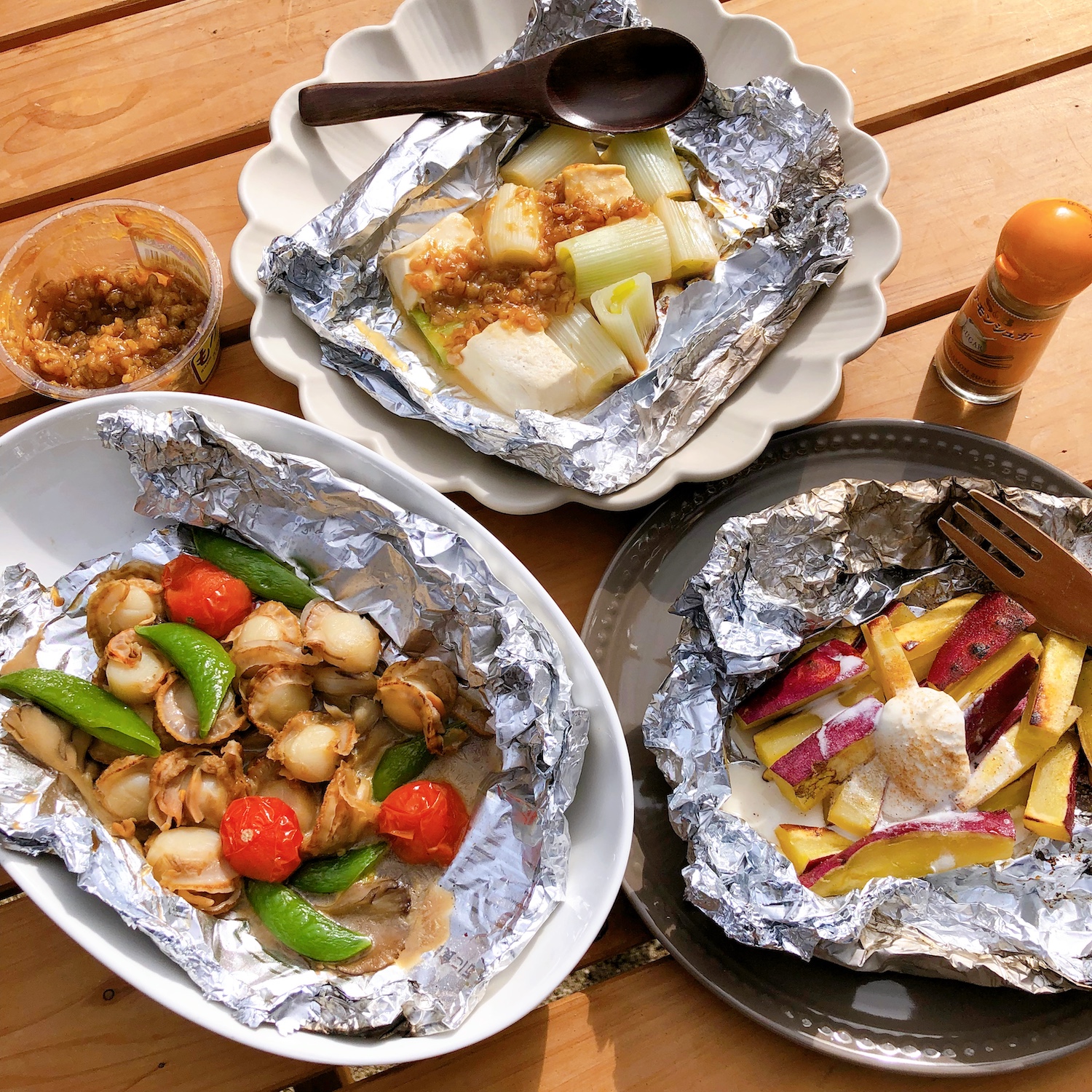 テーブルの上に置いた、ネギと豆腐のみそ焼きとホタテと野菜のバター醤油焼き、おさつバターバニラアイス乗せともろみみそとシナモンシュガー