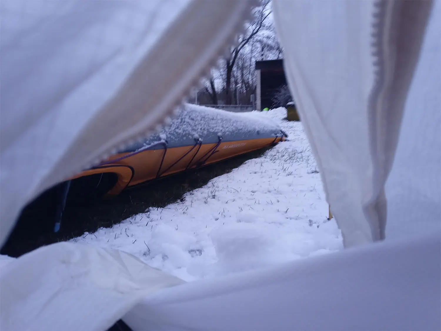 テントから見える雪に覆われたカヤック