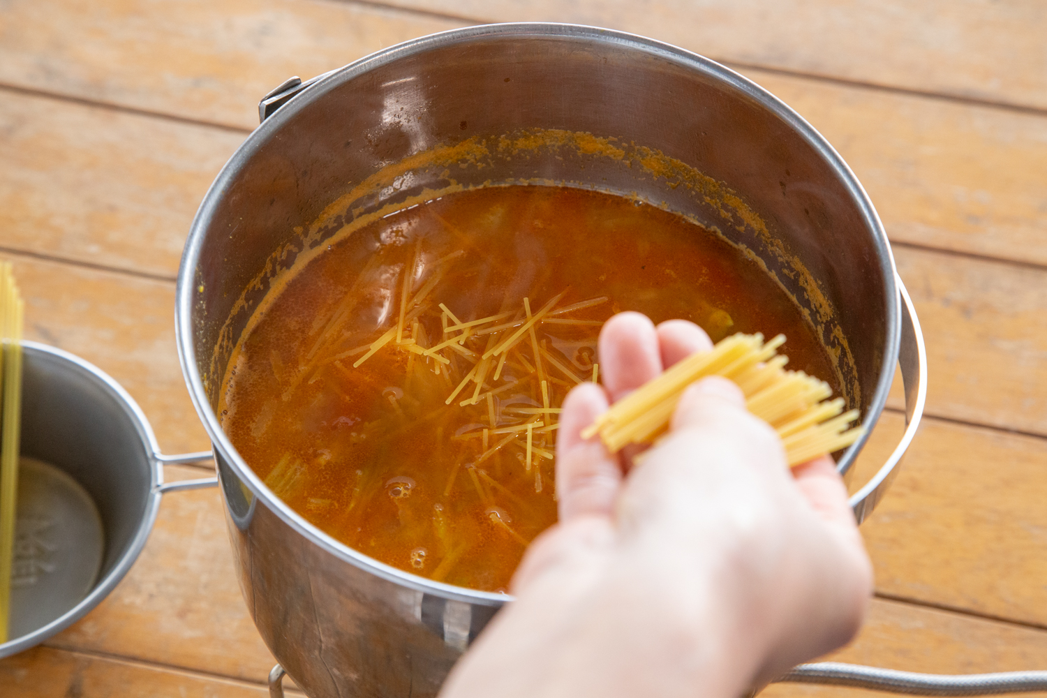 パスタを折って鍋に入れる様子。