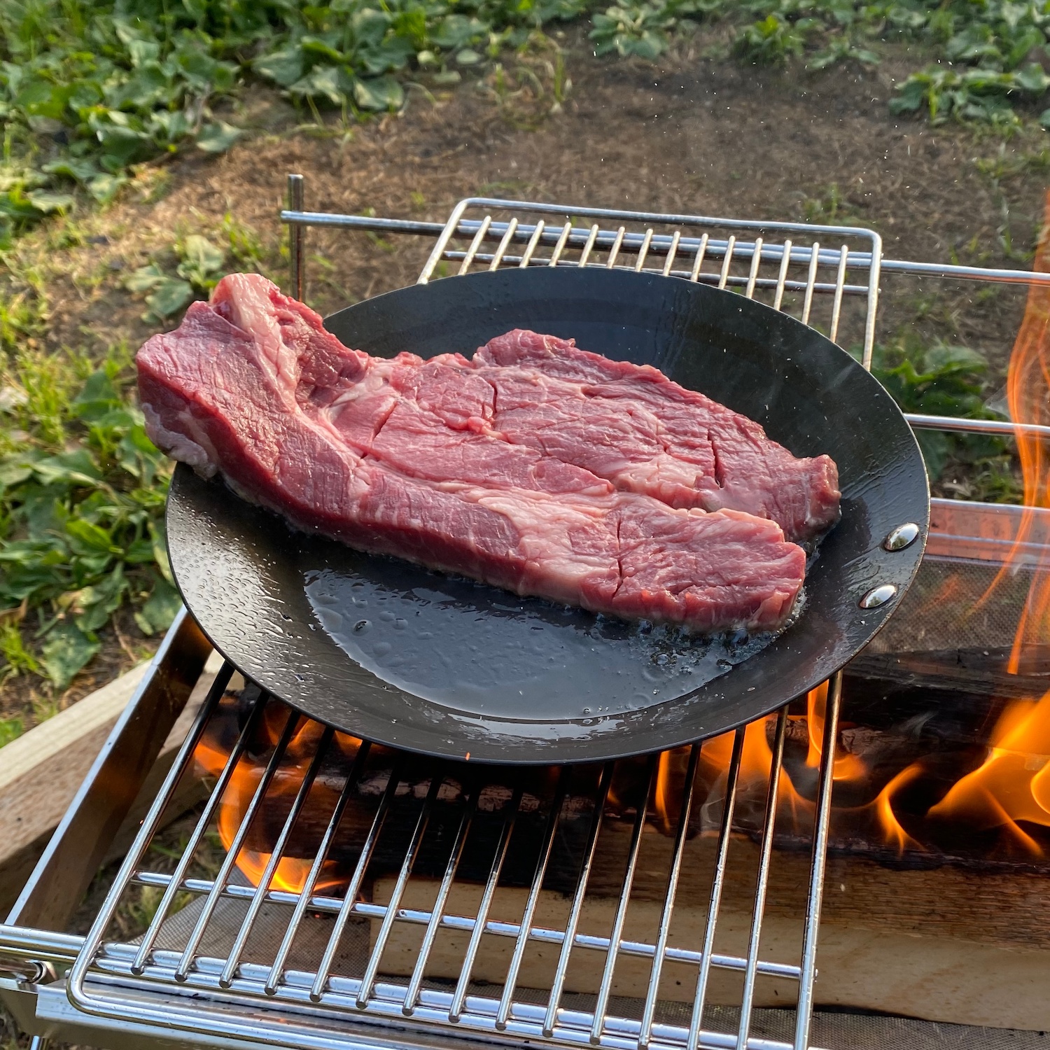 鉄フライパンでステーキを焼いてる