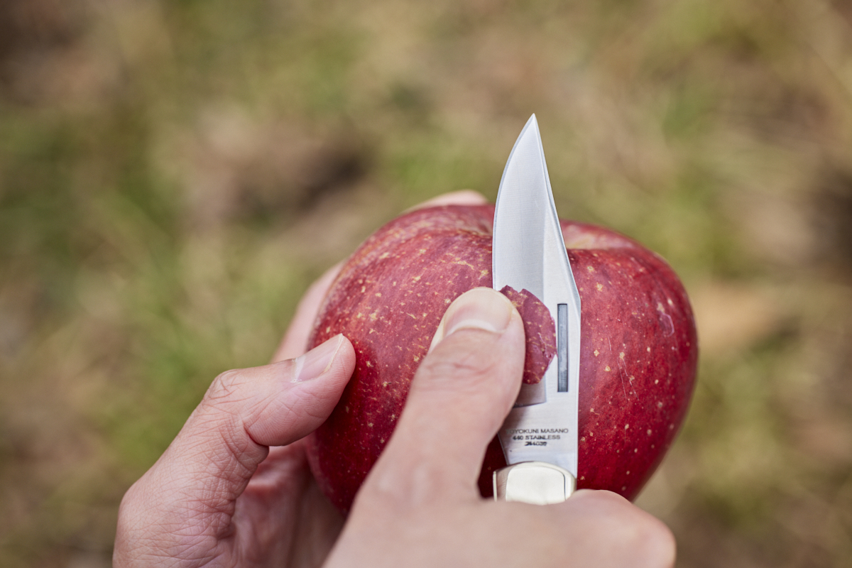 ナイフでリンゴの皮をむいている。