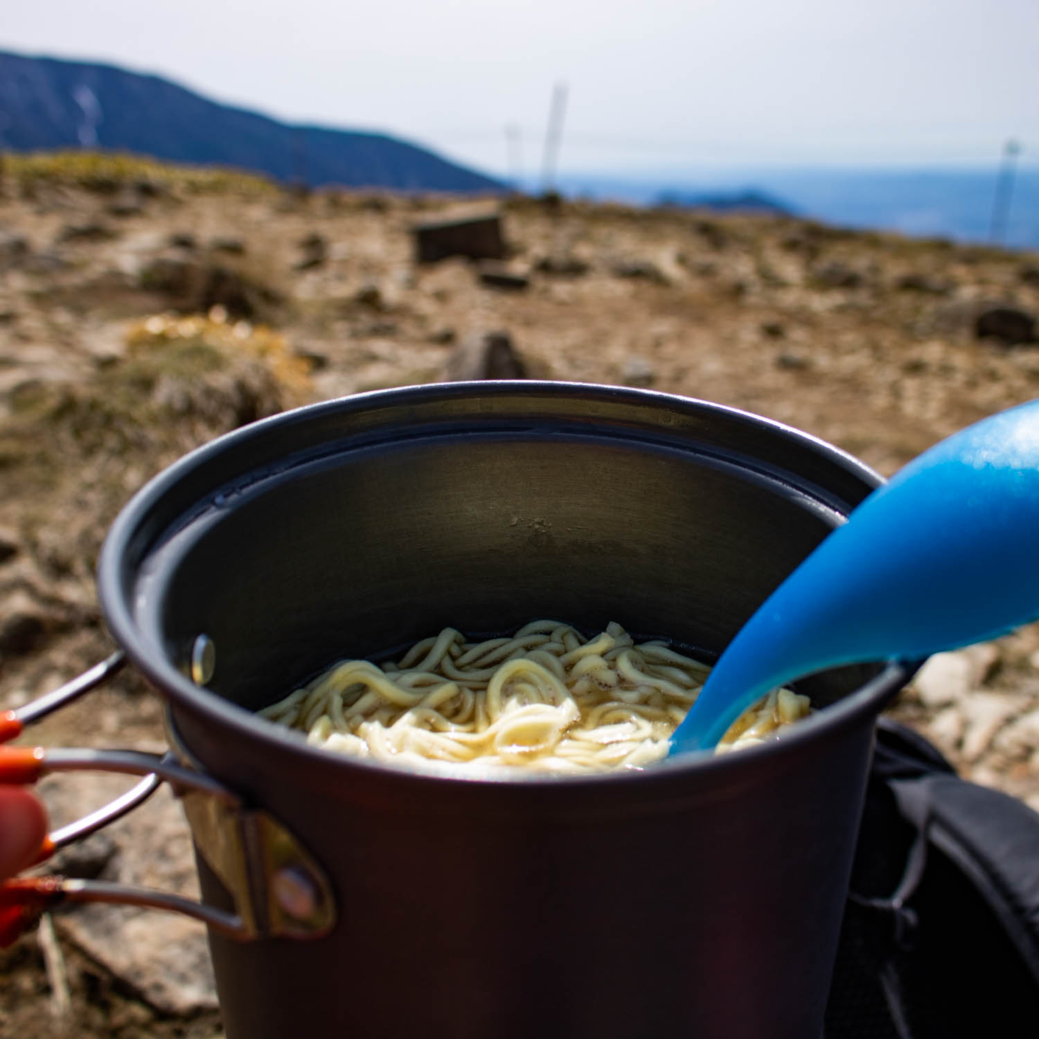 クッカーでラーメンを調理している。