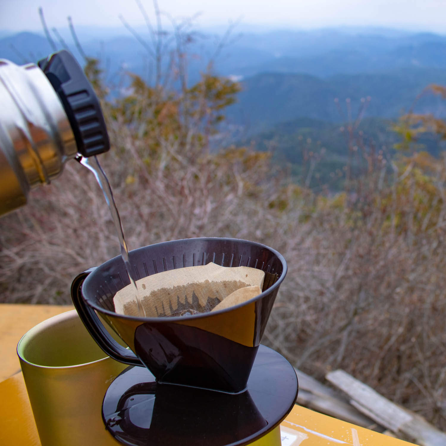 山の上でドリップコーヒーをいれている。