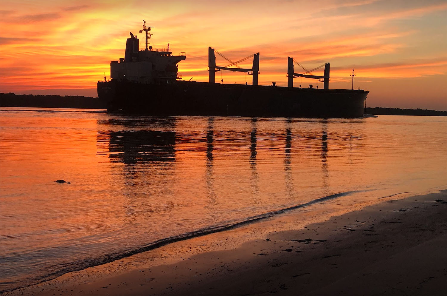 ミシシッピ川で夕日をバックにした石油タンカー