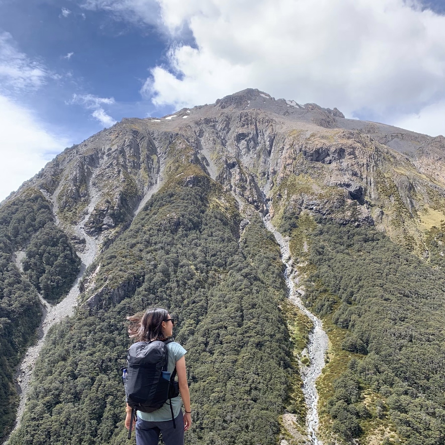 登山者が聳え立つ山を眺めている。