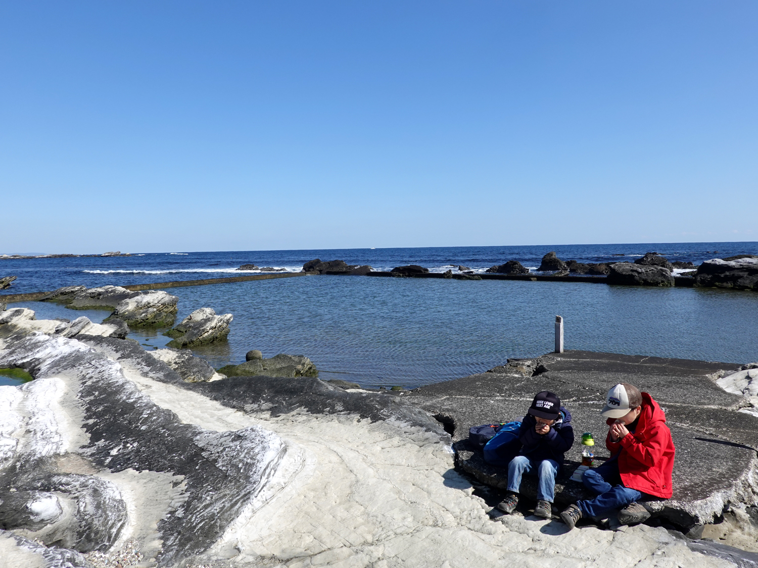 海辺でおにぎりを食べる子ども