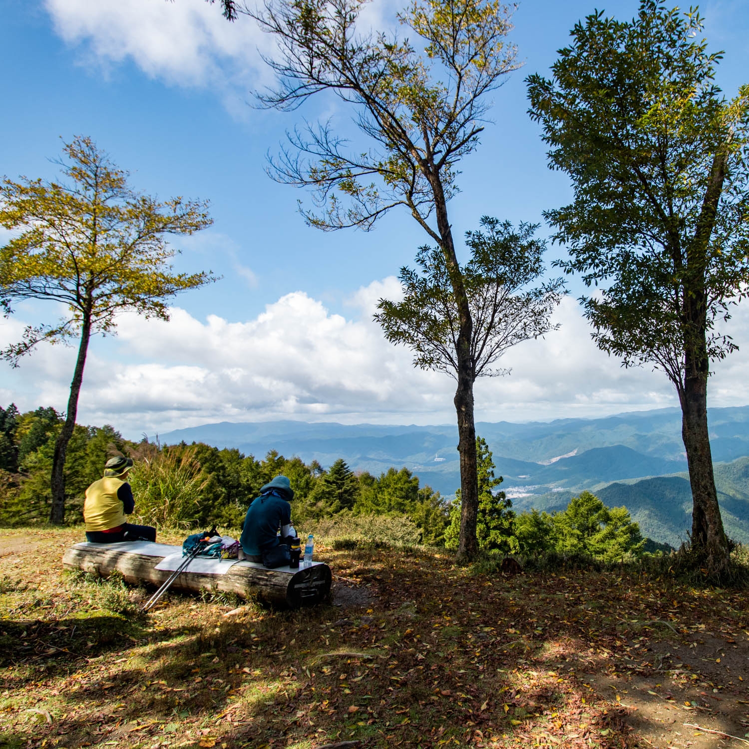 登山者二人がベンチに座っている。