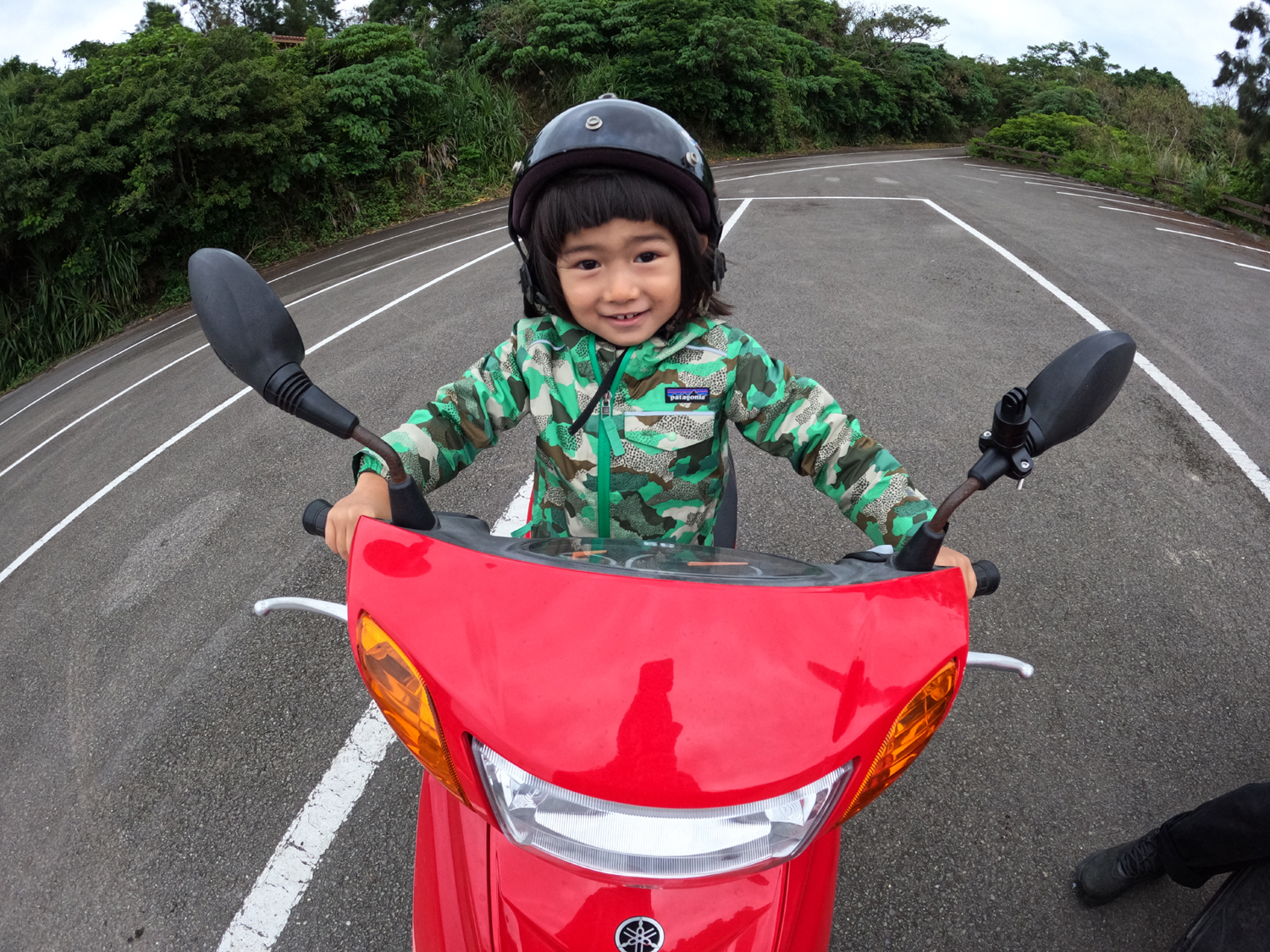 オートバイにまたがり笑顔の子ども