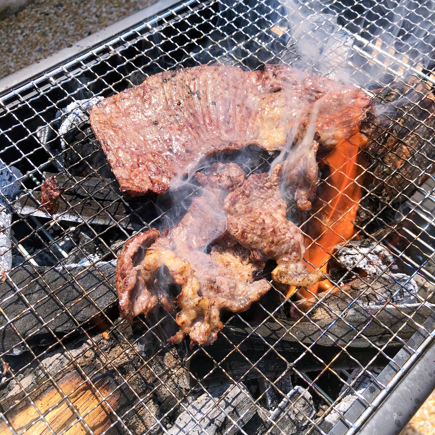 網の上で焼かれるステーキ。