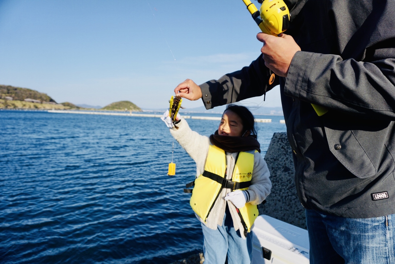 子どもが魚を釣り上げている