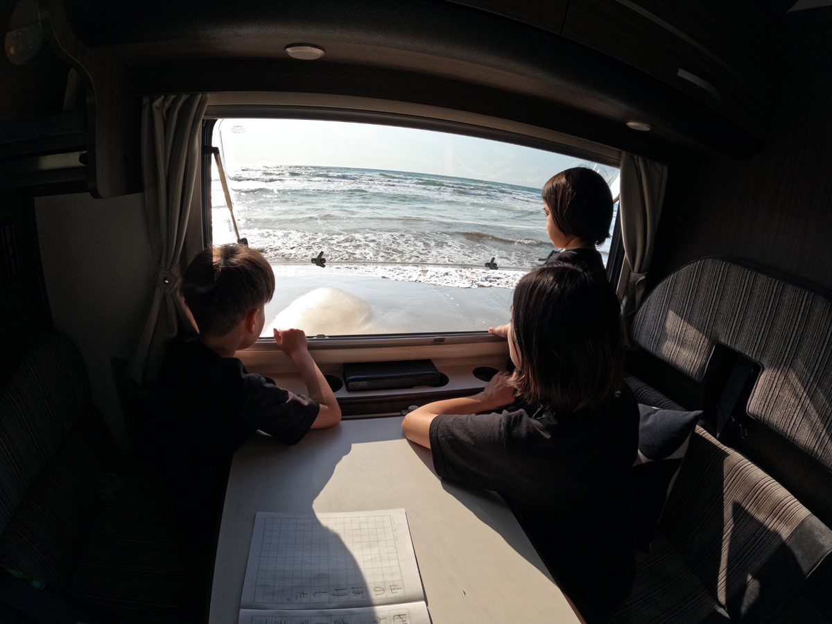 日本海に面した石川県の千里浜にて、波打ち際にキャンピングカーを停めて「チルタイム」。