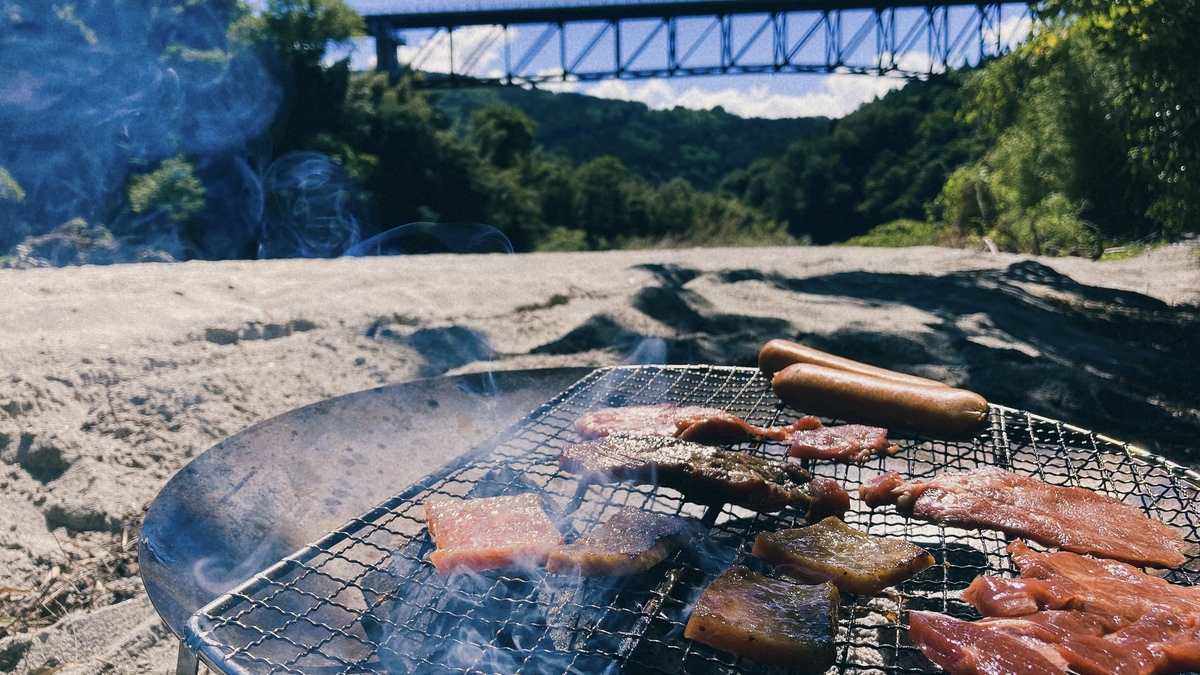 焚き火で肉を焼いている。