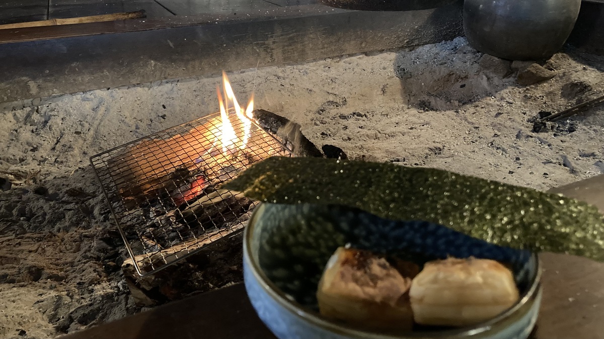 囲炉裏の前にお餅と海苔が置いてある。