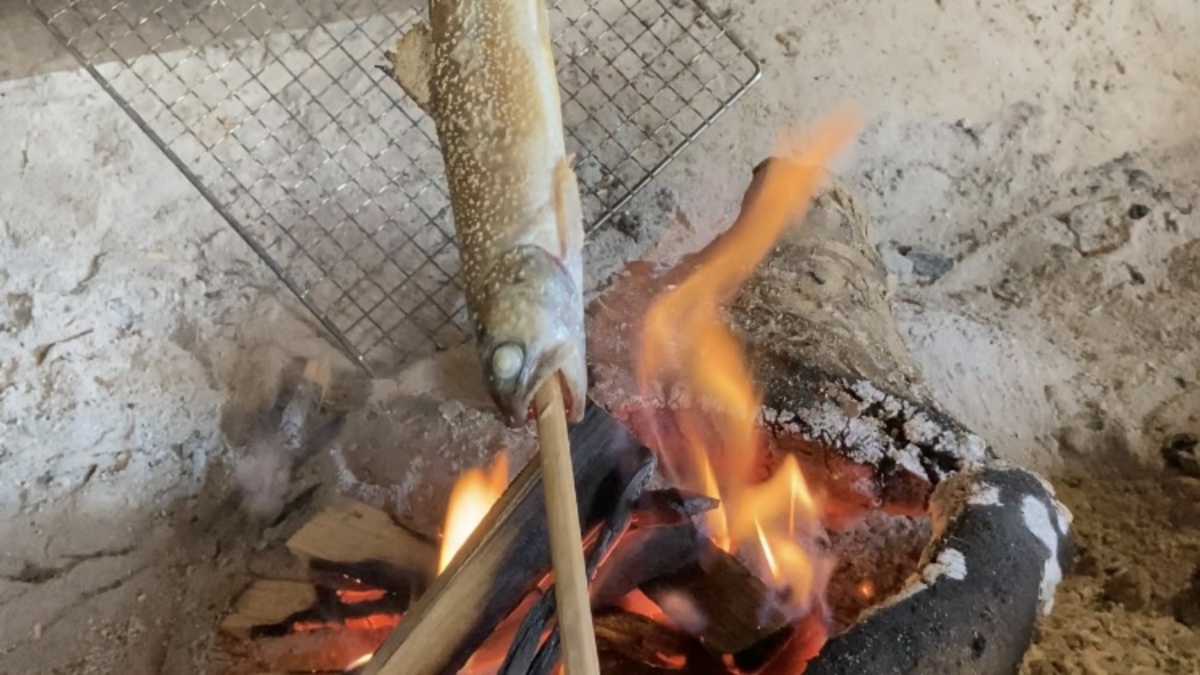 囲炉裏で魚を焼いている。