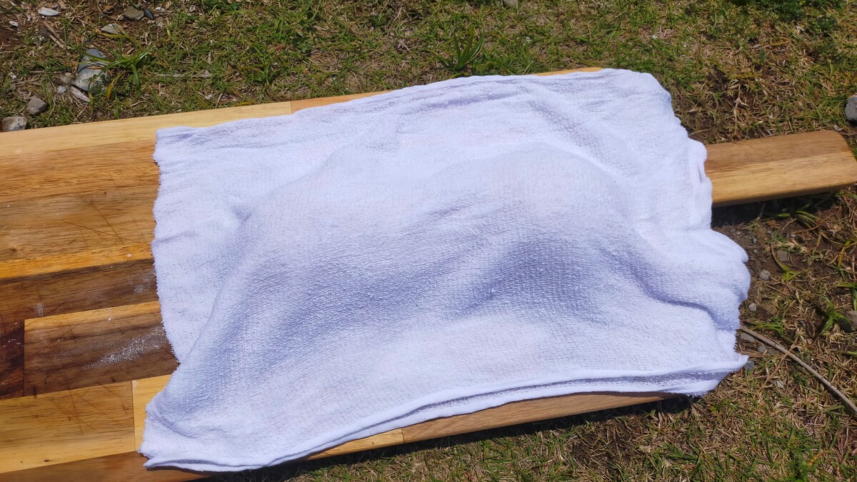 パン生地の上にタオルがかけられている。