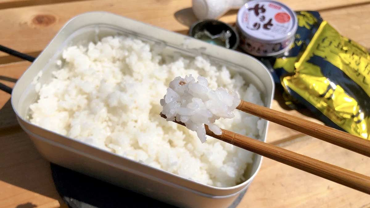 メスティンで炊飯したご飯を箸ですくう。