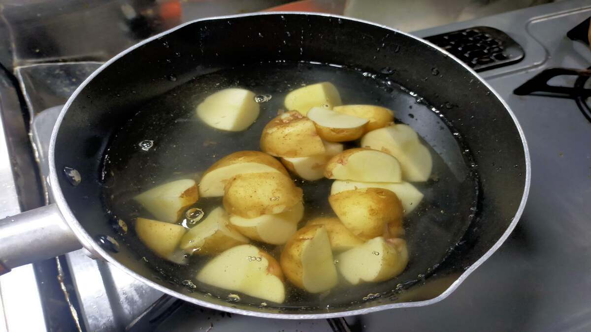 ジャガイモとジャガイモが浸るほどの水が入った鍋が火にかけられている