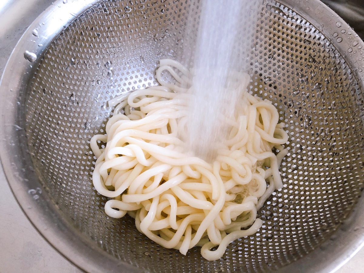 流水麺をザルに出し、流水を当てる。