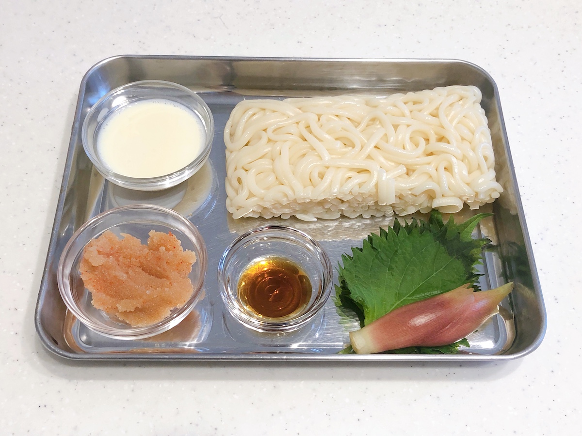 バッドの上の流水麺うどん、豆乳、明太子、白だし、大葉、茗荷。