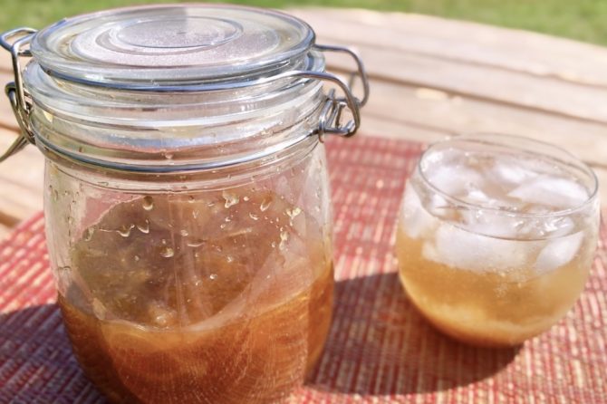 瓶に入れたジンジャーエールシロップとコップに入ったジンジャーエール