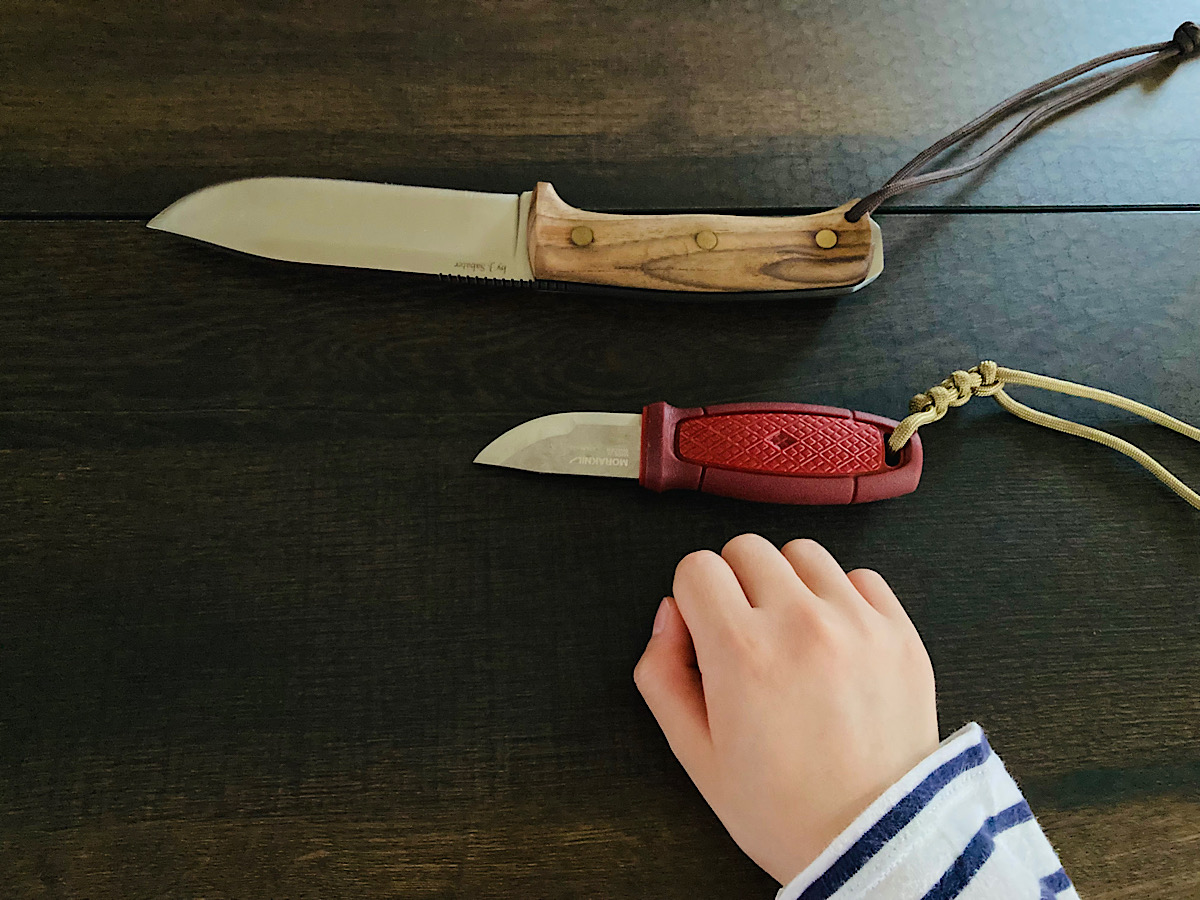 子どもの手とナイフの刃の大きさを比べている様子です。