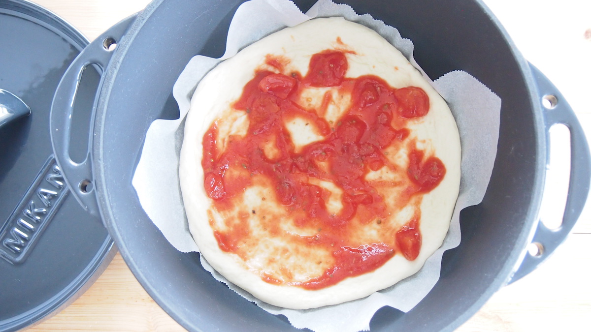ピザ生地にトマトソースを塗る