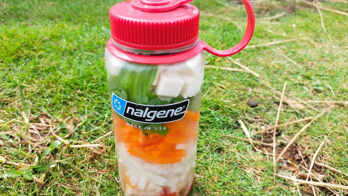 サラダが入ったボトルが芝の上に置かれている。