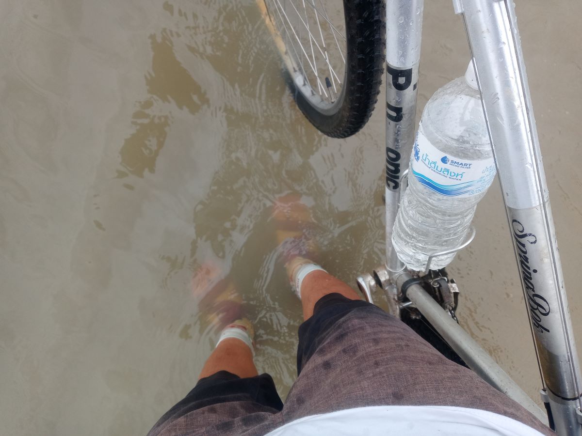 冠水した道路を自転車で進む