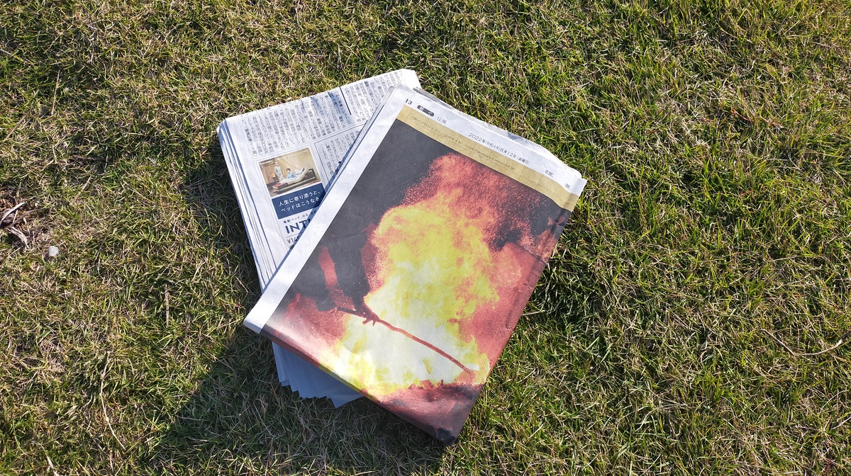 新聞紙が芝の上に置かれている。