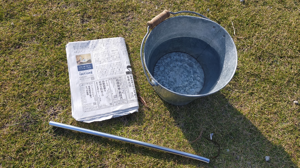 紙薪作りに必要な道具が地面に置いてある。