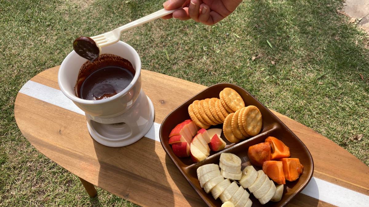 フルーツをチョコフォンデュにつけて食べている