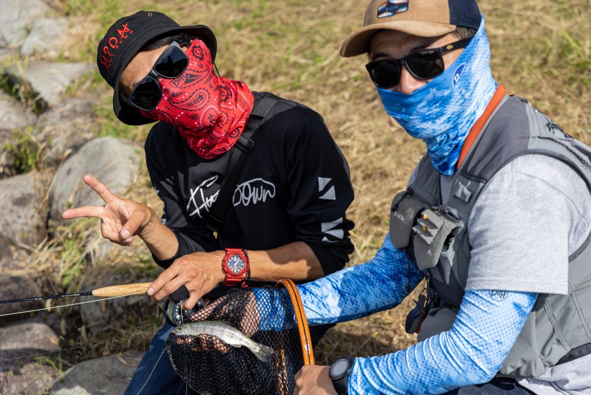 バフを着用して魚を釣りあげた男性二人組