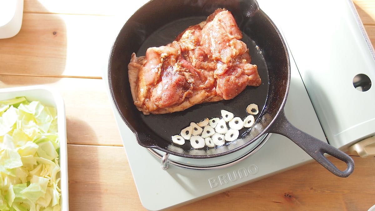 ニンニクの隣で鶏肉を焼く