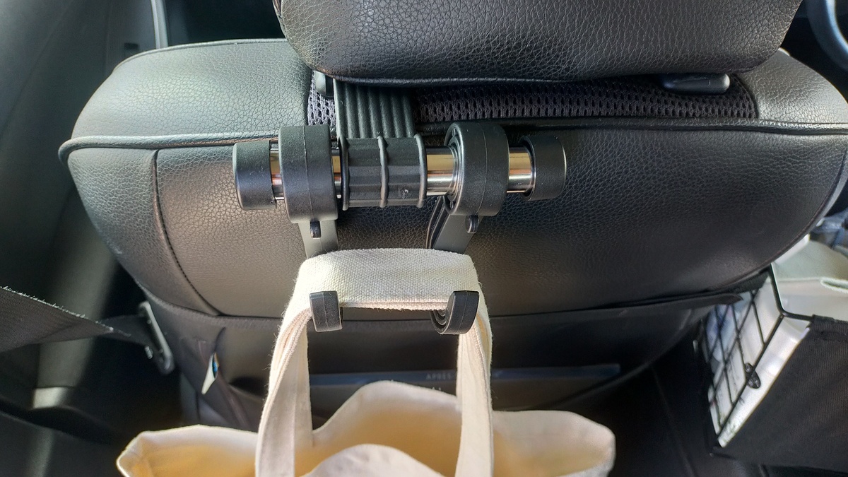 車のシートフックがヘッドレストのポールに固定されている様子。