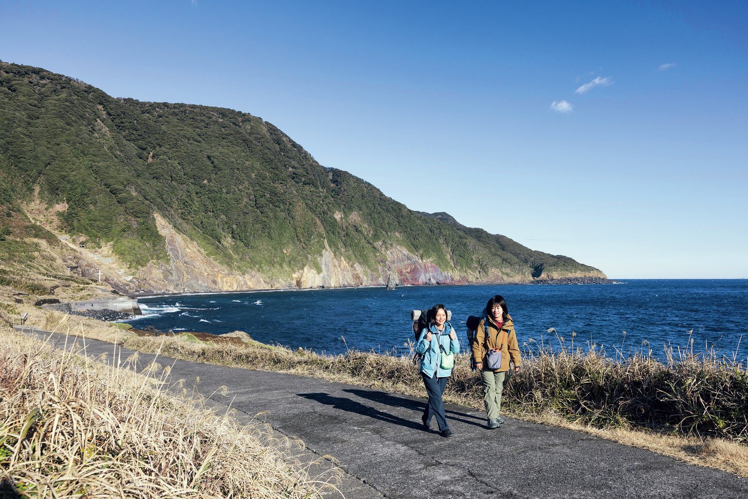 海沿いを歩く女性2人