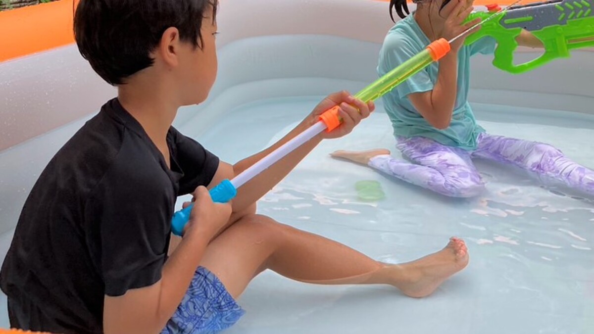 子どもがスプラッシュ水鉄砲で水を発射している様子。