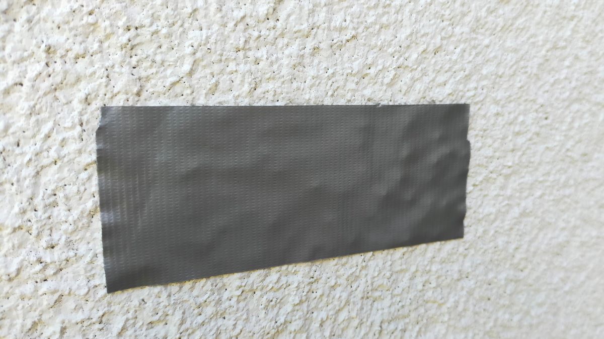 凸凹の家の壁にゴリラテープが貼りついている様子。